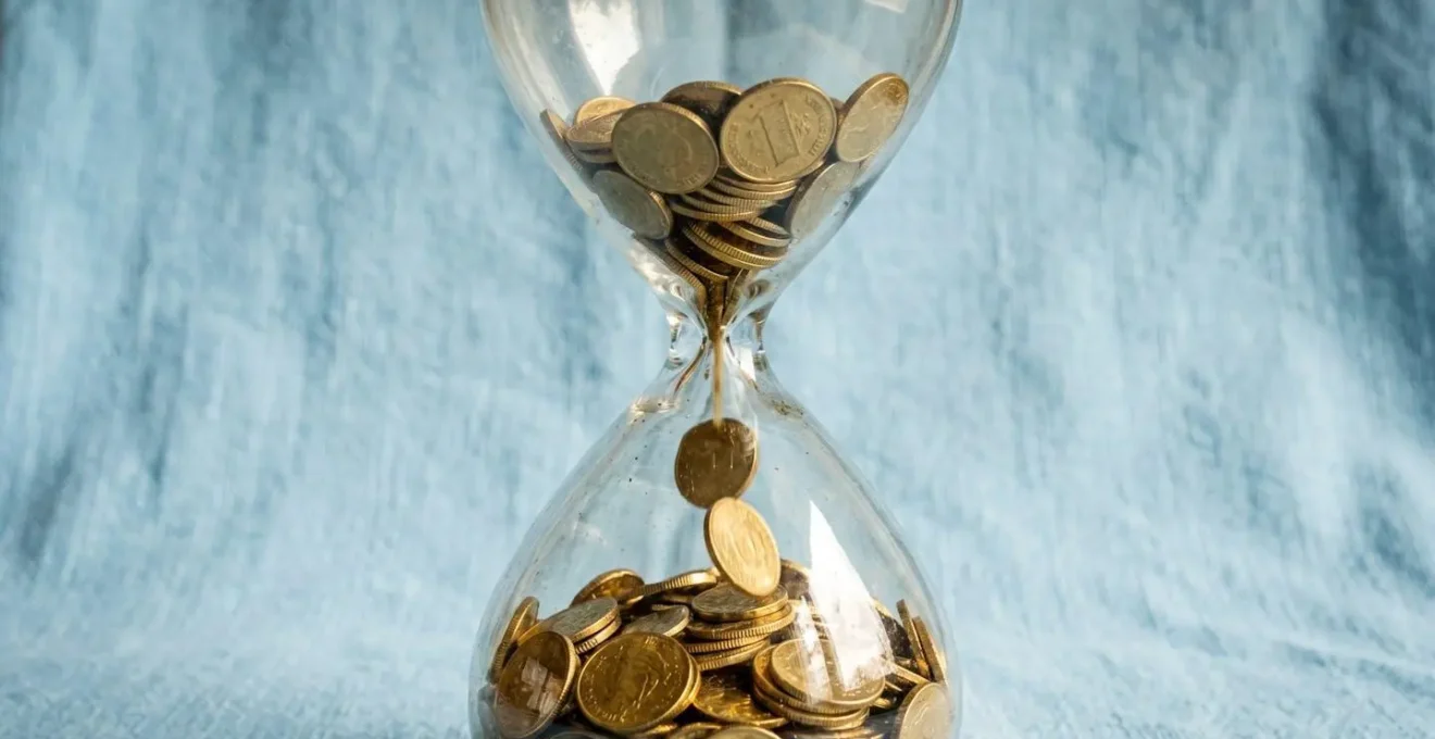 Un sablier contenant des pièces d'or, symbole d'un revenu régulier inépuisable.